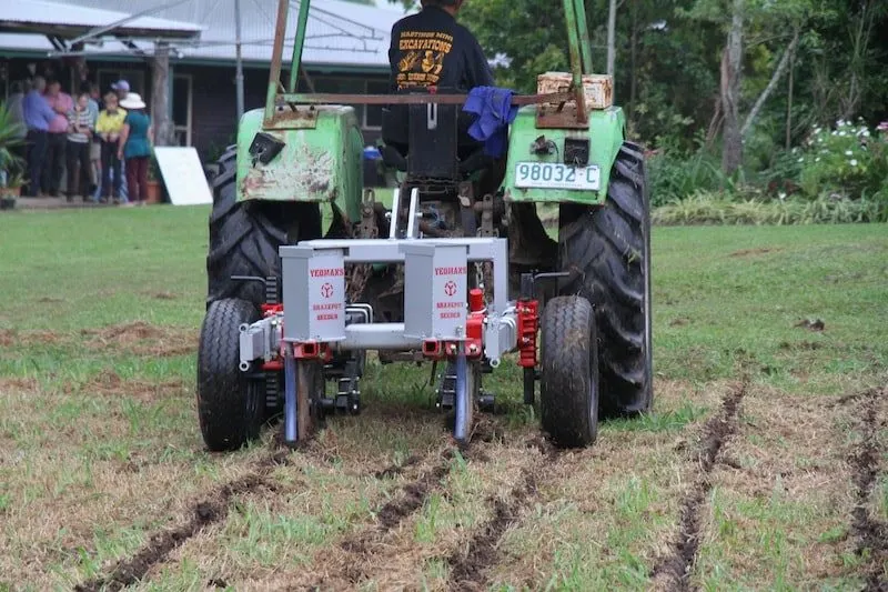 Tractor with a Yeomans plough attachment cutting contour lines into a grassed paddock